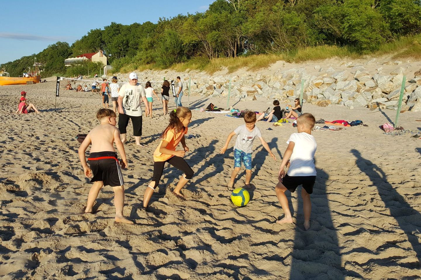 Dzieci grające w piłkę plażową podczas letniego obozu PCR Sport